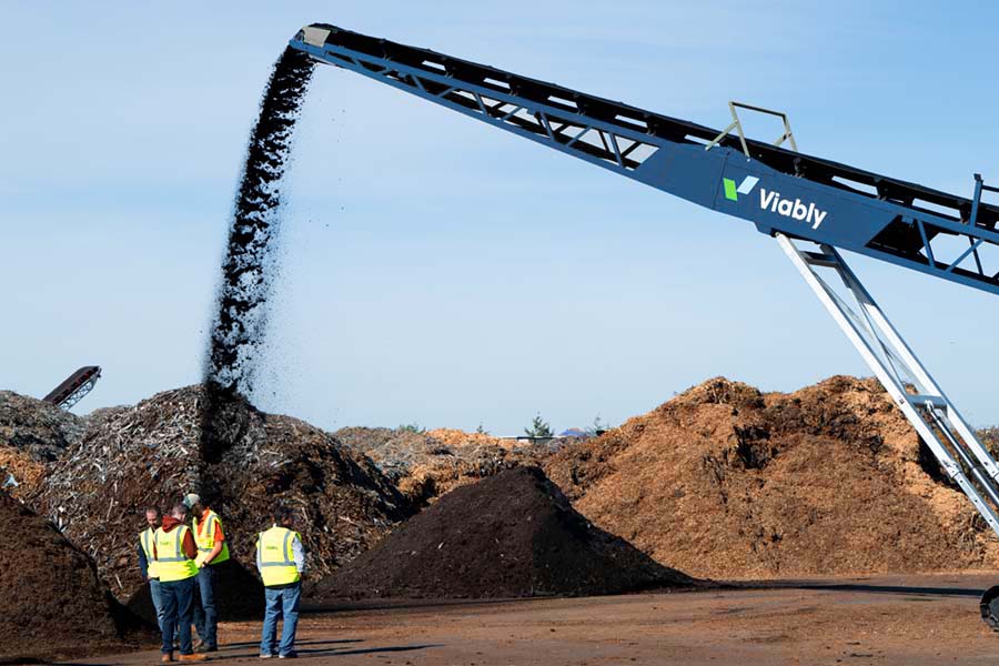 A Viably mobile conveyor discharging compost into a pile.