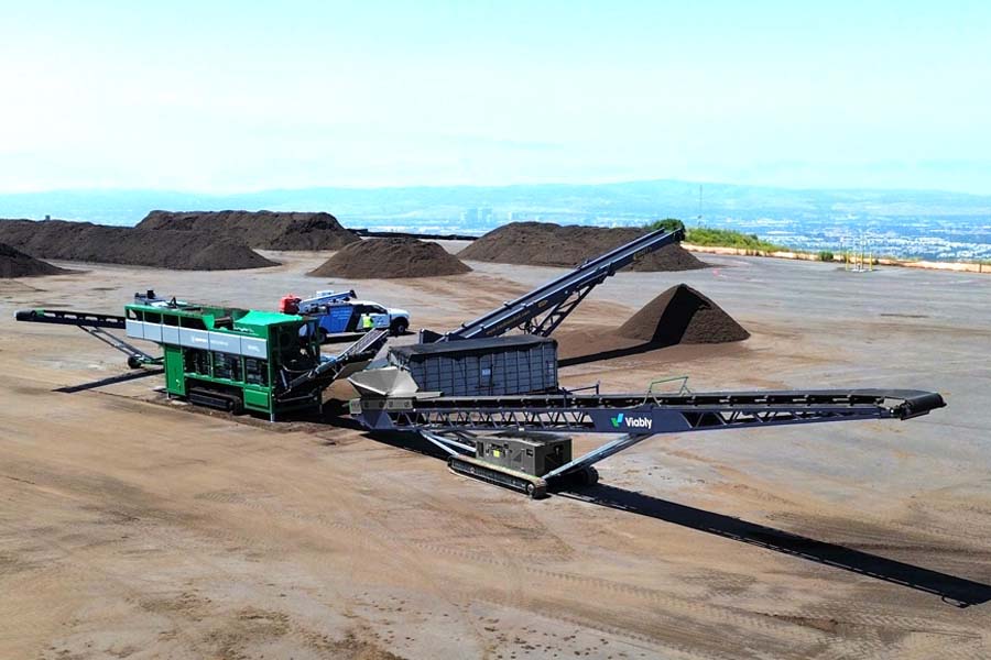 A wide shot of a Viably mobile conveyor being fed compost from a Komptech Multistar star screen.